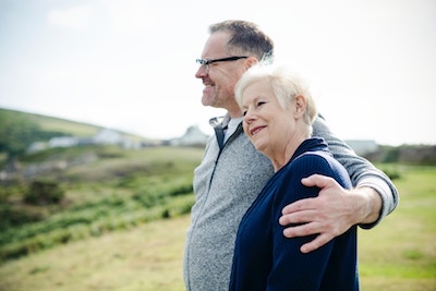 elderly couple with arms around each other