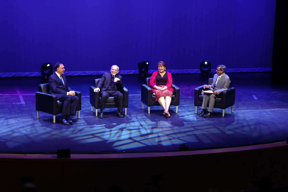 Dr. Fernando Guerra panel of guests all seated in chairs on a lighted auditorium stage