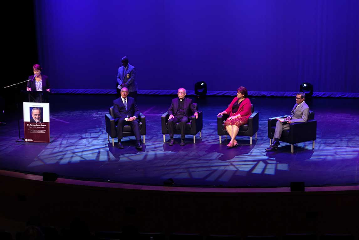 Dr. Fernando Guerra panel of guests all seated in chairs on a lighted auditorium stage